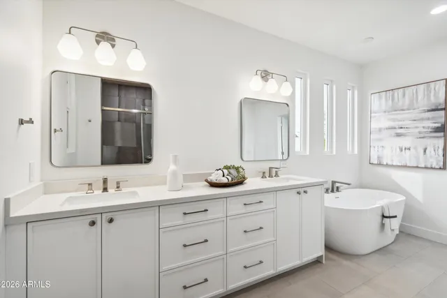 a bathroom with a double vanity sink mirror and bathtub