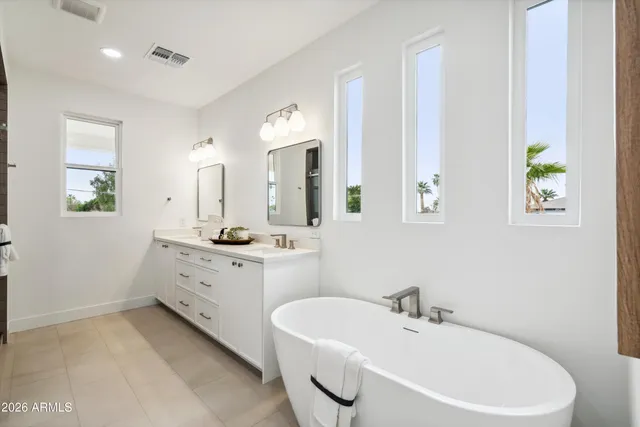 a bathroom with a white tub sink and mirror
