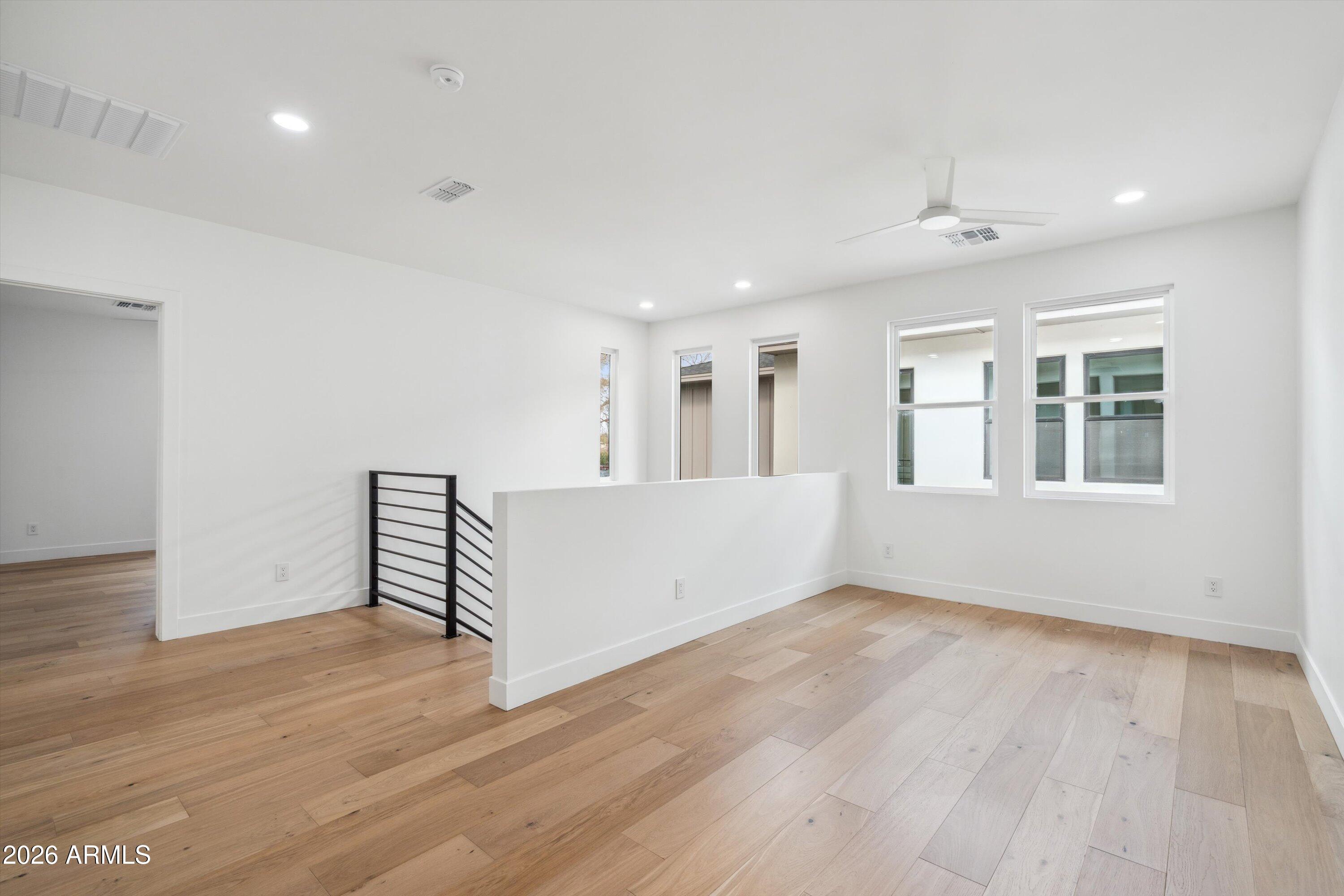 5533 East Earll Drive Phoenix, AZ 85018 - Photo 32 of 42 an empty room with wooden floor and windows