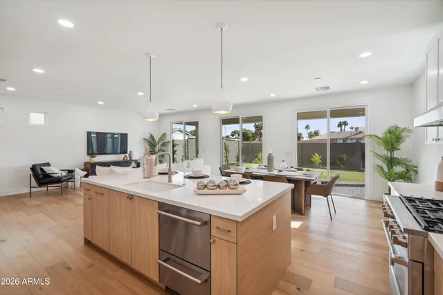 a kitchen with kitchen island stainless steel appliances a sink stove and cabinets