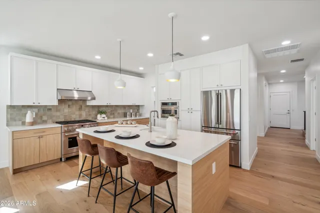a kitchen with kitchen island a stove a table and chairs in it