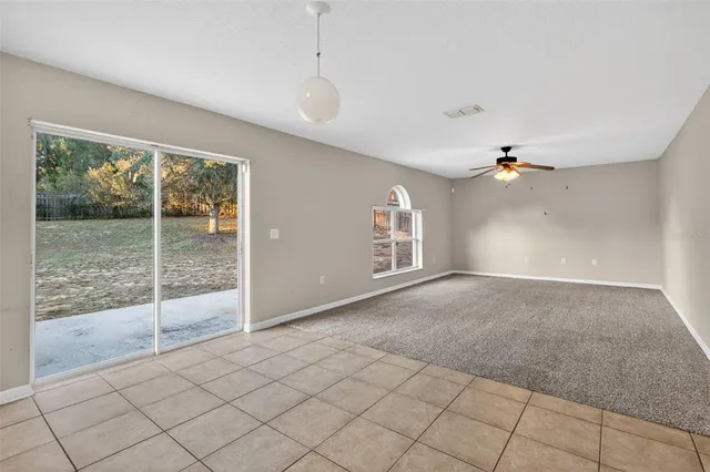 an empty room with windows and chandelier