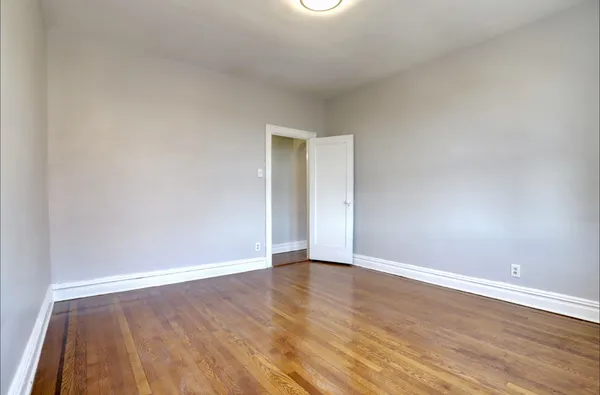 a view of an empty room with wooden floor