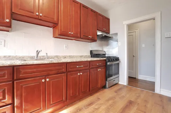 a kitchen with granite countertop wooden cabinets and a sink