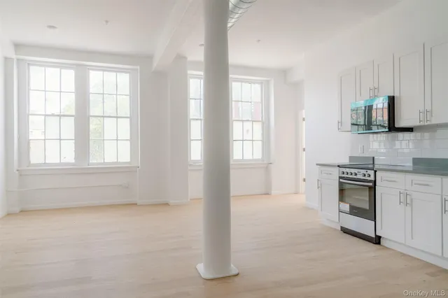 a kitchen with granite countertop a stove a sink and a microwave