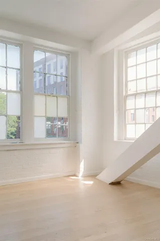 an empty room with wooden floor and a window