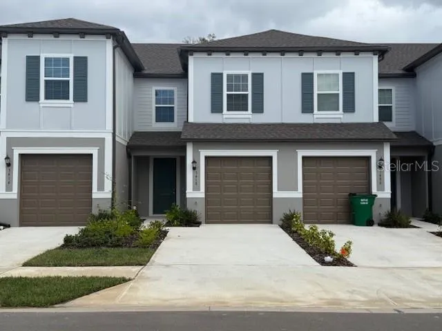 a front view of a house with yard and tress