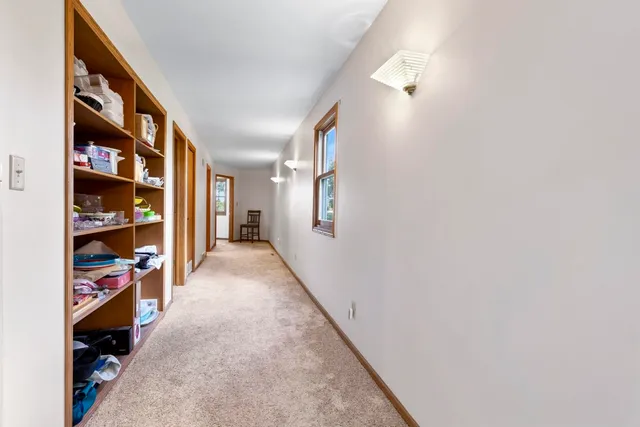 a view of a hallway with closet and a window