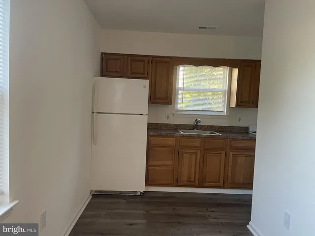 a view of kitchen with granite countertop cabinets and a sink