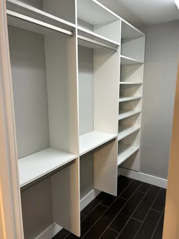 a kitchen with a refrigerator and white cabinets