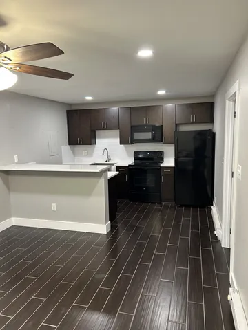 a kitchen with stainless steel appliances a sink a stove top oven a refrigerator and cabinets