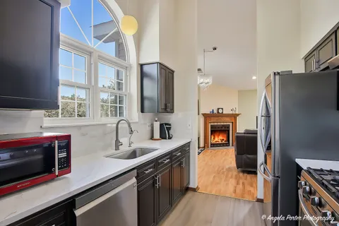 a view of a kitchen with fridge and wooden floor