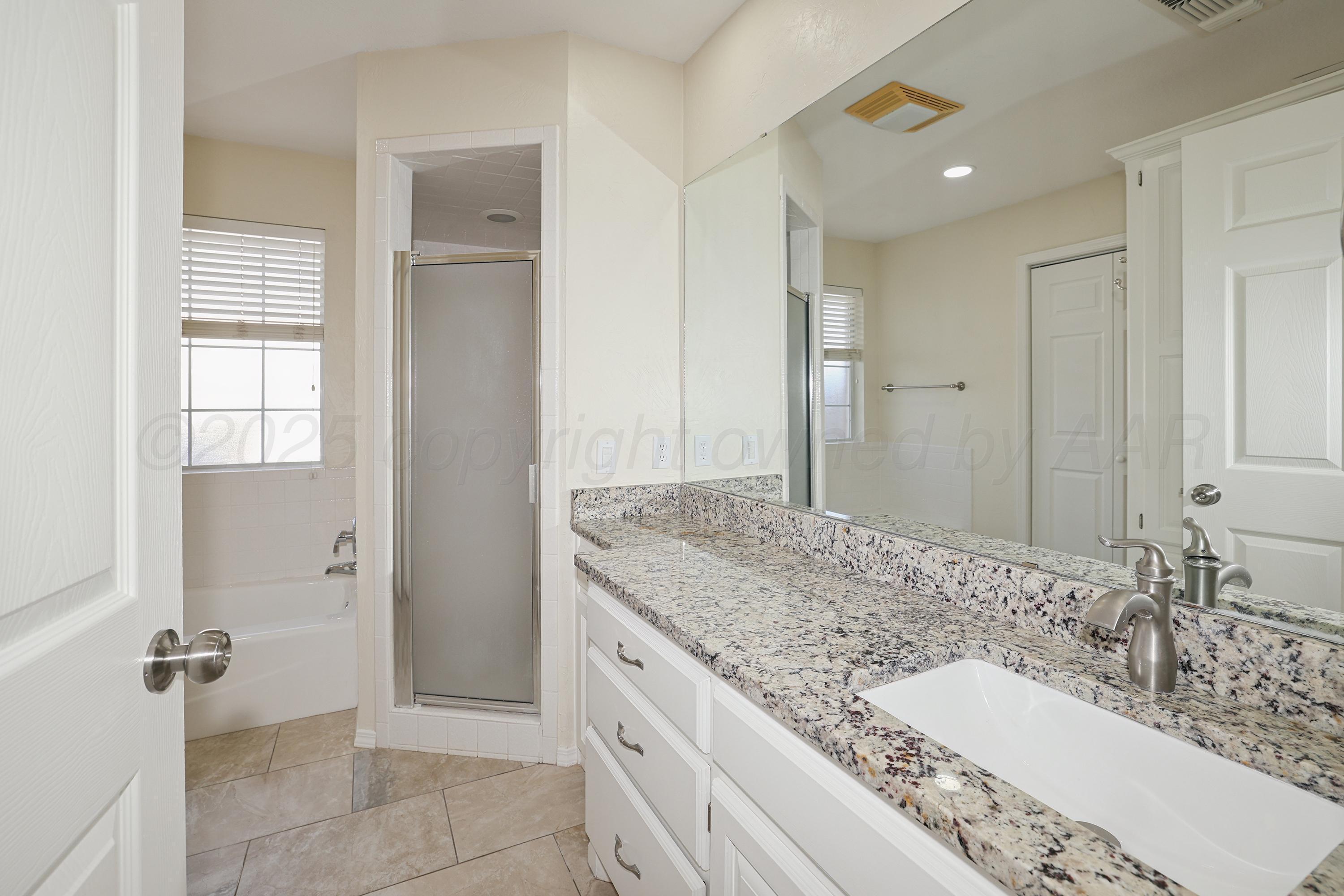6212 Oakcrest Lane Amarillo, TX 79109 - Photo 11 of 33 a bathroom with a granite countertop sink and a mirror