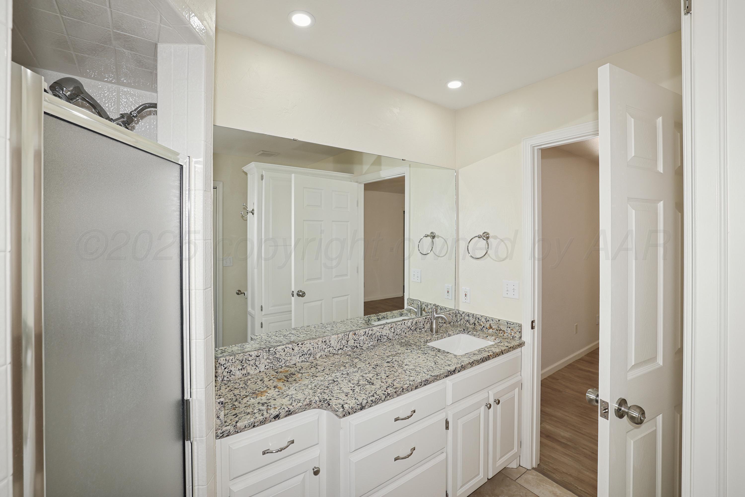 6212 Oakcrest Lane Amarillo, TX 79109 - Photo 13 of 33 a bathroom with a granite countertop sink mirror and shower
