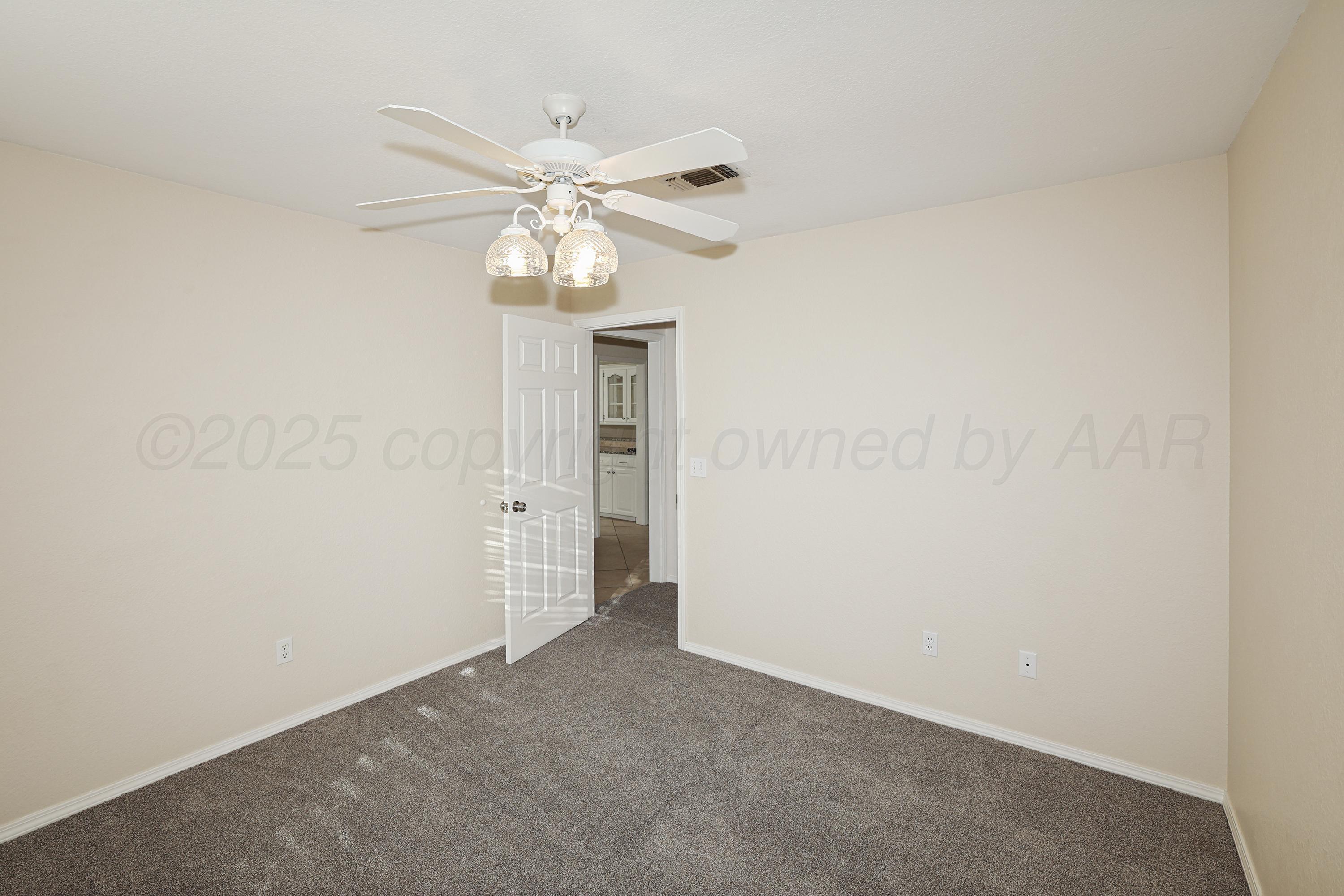 6212 Oakcrest Lane Amarillo, TX 79109 - Photo 19 of 33 an empty room with a chandelier fan and closet