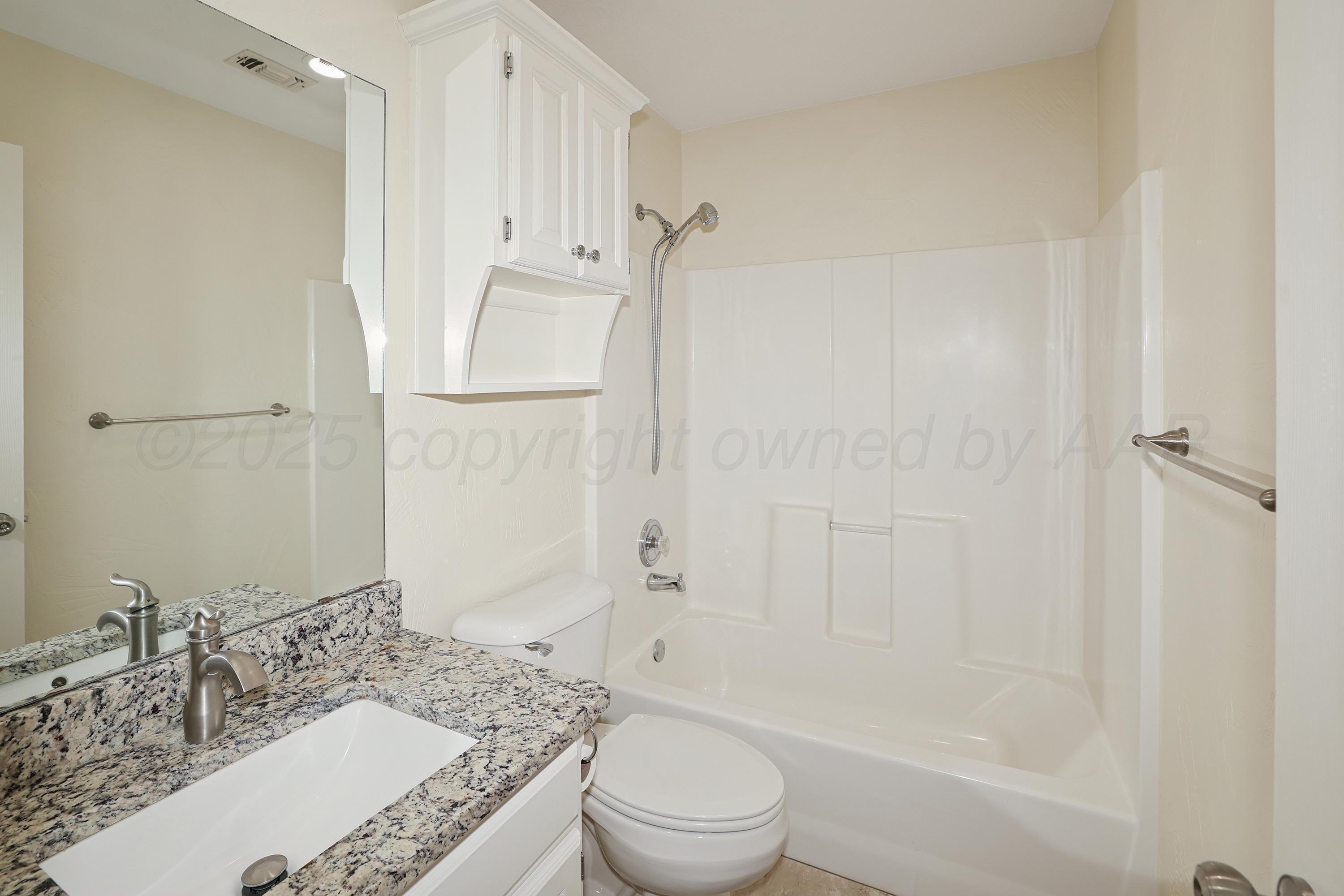 6212 Oakcrest Lane Amarillo, TX 79109 - Photo 20 of 33 a bathroom with a granite countertop sink toilet and shower