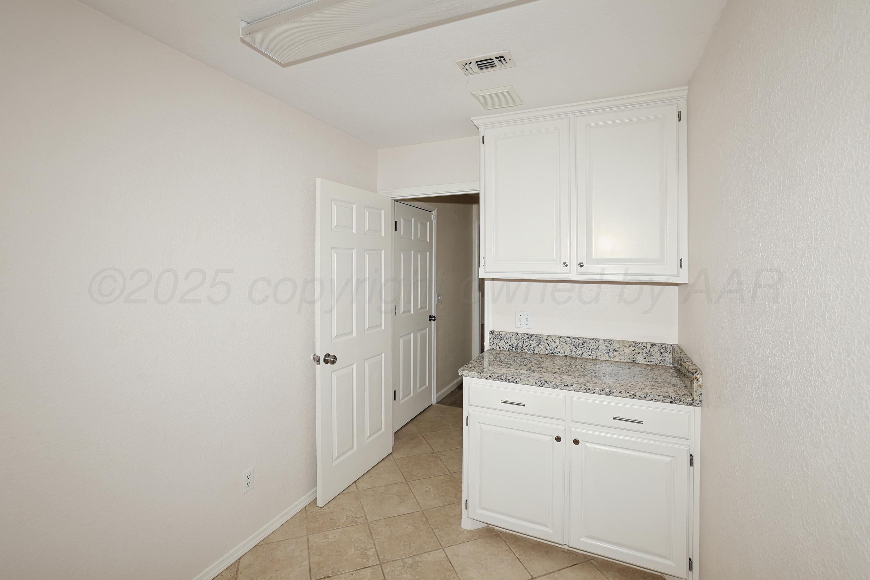 6212 Oakcrest Lane Amarillo, TX 79109 - Photo 22 of 33 a bathroom with a granite countertop sink and white cabinets