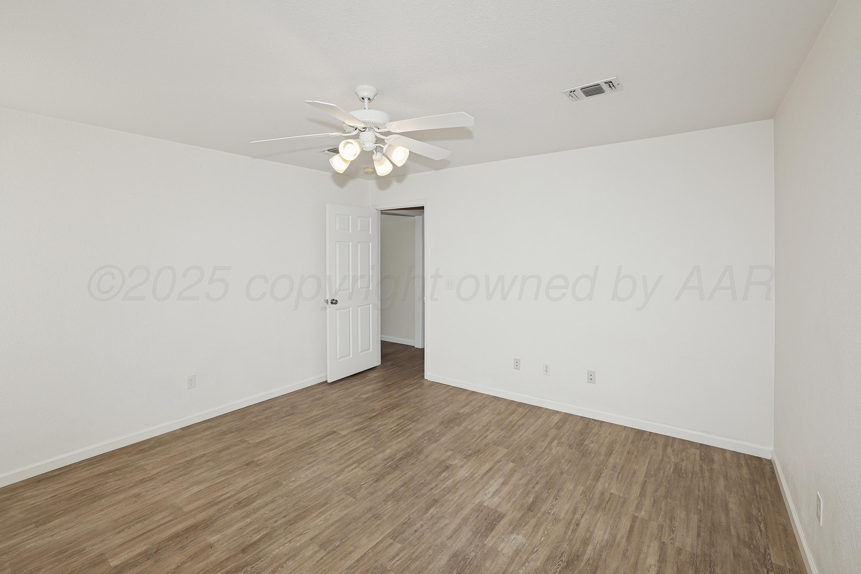 6212 Oakcrest Lane Amarillo, TX 79109 - Photo 29 of 33 an empty room with wooden floor and ceiling fan