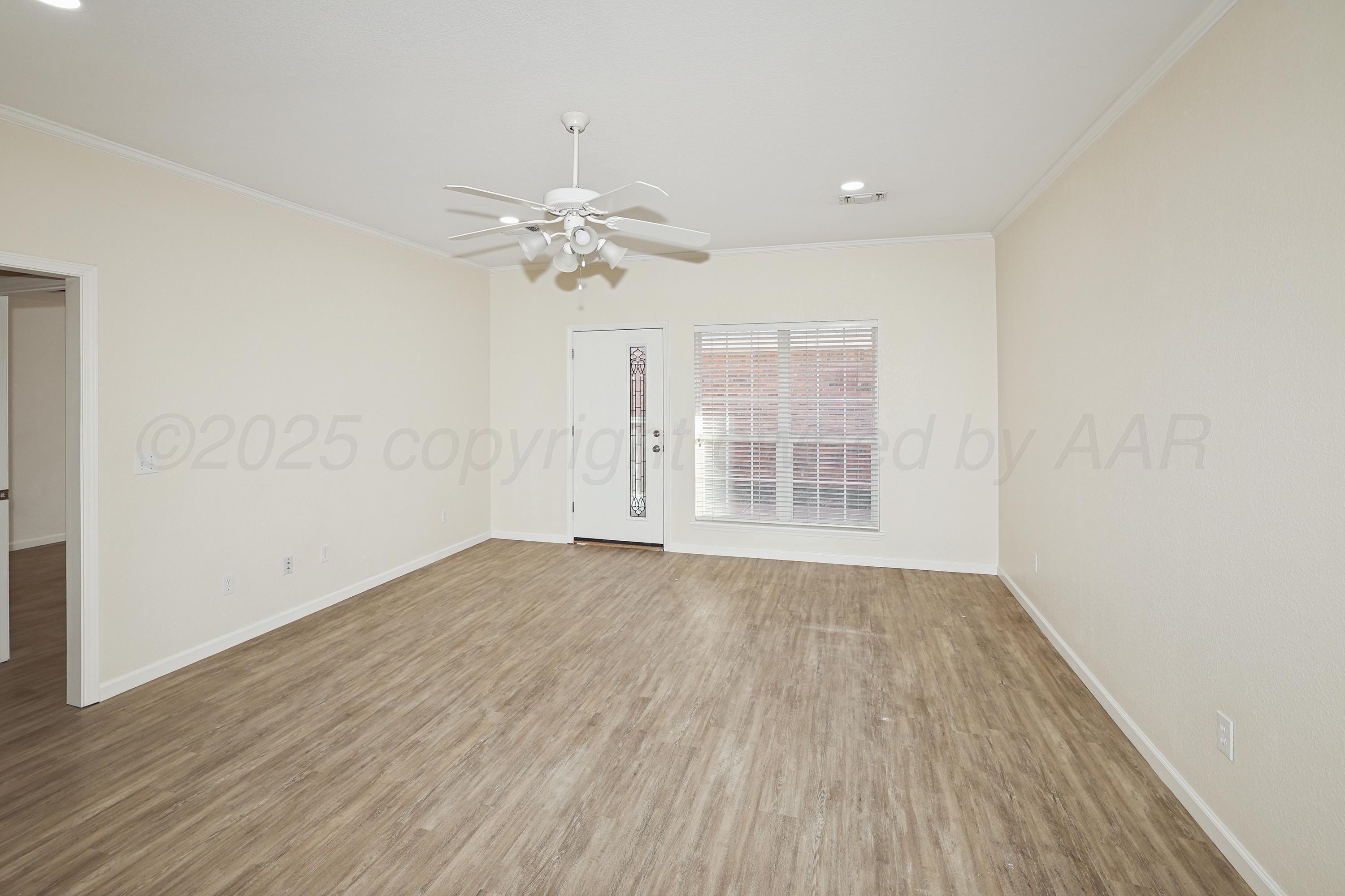 6212 Oakcrest Lane Amarillo, TX 79109 - Photo 6 of 33 wooden floor in an empty room with a window