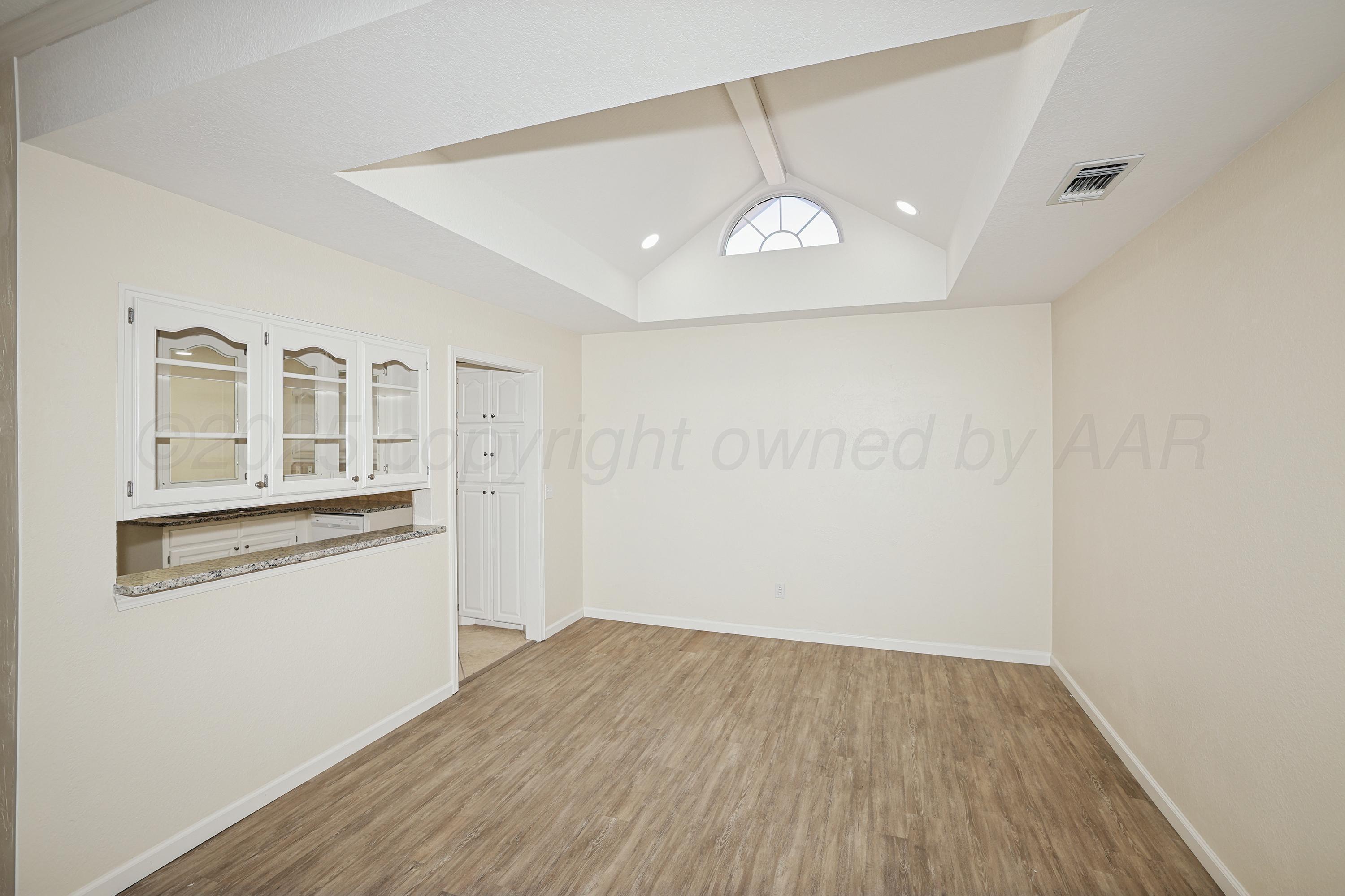 6212 Oakcrest Lane Amarillo, TX 79109 - Photo 8 of 33 wooden floor in an empty room with a window
