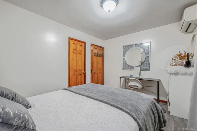 a bedroom with a bed a mirror on dresser and a chandelier