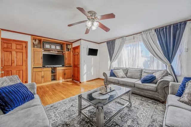 a living room with furniture flat screen tv and a large window