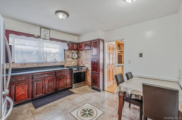 a large kitchen with stainless steel appliances granite countertop a stove and a refrigerator