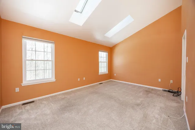 an empty room with windows & cabinet