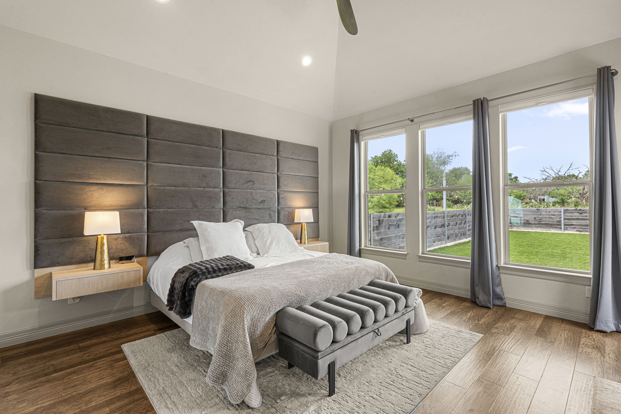 16202 Remuda Trail Buda, TX 78610 - Photo 11 of 40 Primary bedroom features hardwood style flooring, a vaulted ceiling, and three large windows overlooking the backyard
