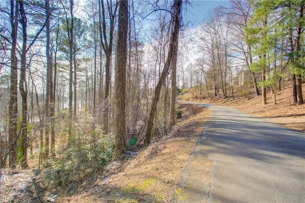 a backyard of a house with large trees and outdoor seating