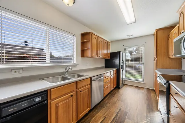 a kitchen with stainless steel appliances sink stove and cabinets
