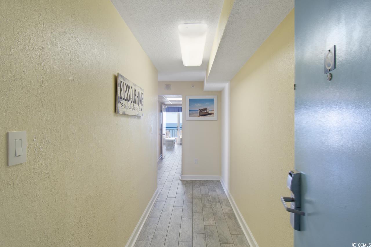 2300 North Ocean Boulevard, Unit 830 Myrtle Beach, SC 29577 - Photo 23 of 33 Hallway with wood finished floors and a textured ceiling