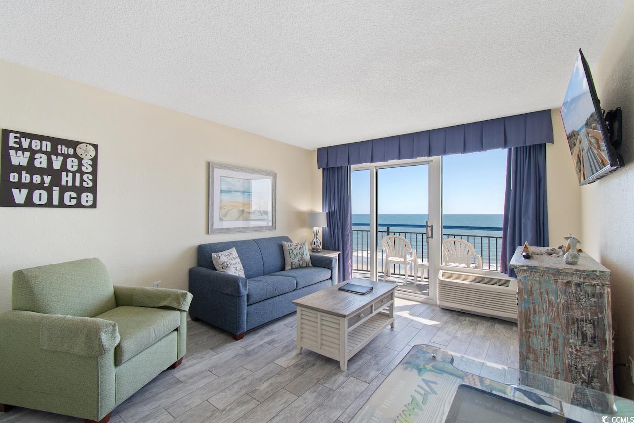 2300 North Ocean Boulevard, Unit 830 Myrtle Beach, SC 29577 - Photo 6 of 33 Living room with a textured ceiling, wood finished floors, and an AC wall unit