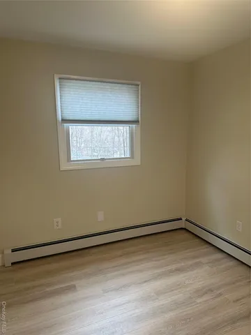 a view of a room with wooden floor and window