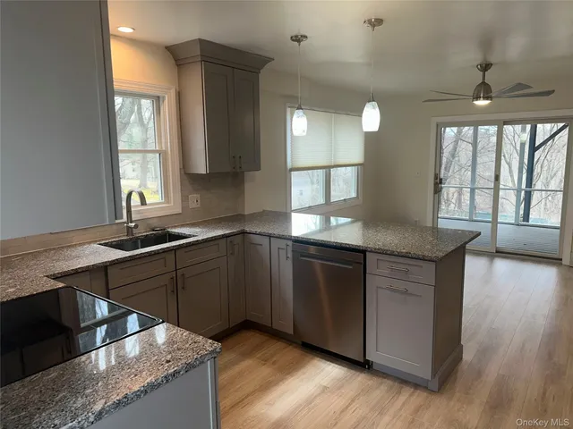 a kitchen with granite countertop a stove a sink and a large window