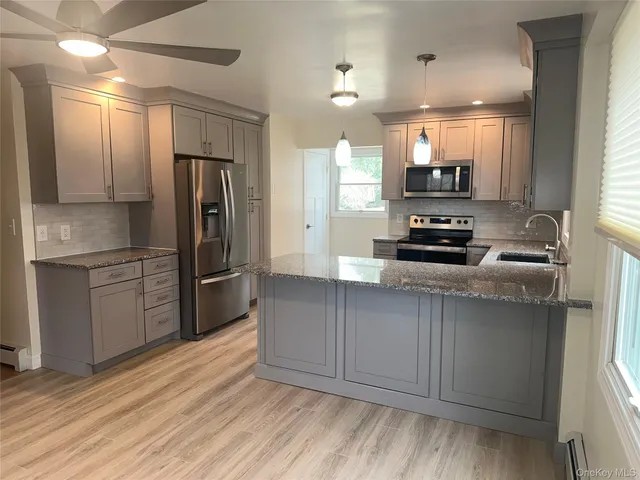 a kitchen with stainless steel appliances a refrigerator sink and microwave