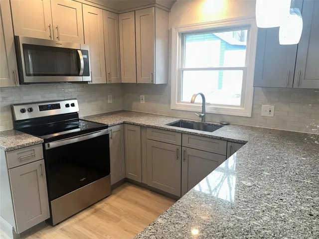 a kitchen with stainless steel appliances granite countertop a sink stove microwave and cabinets
