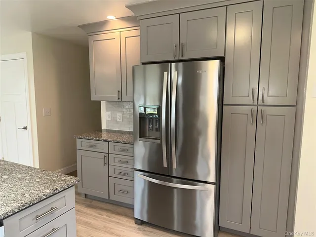 a metallic refrigerator freezer sitting inside of a kitchen