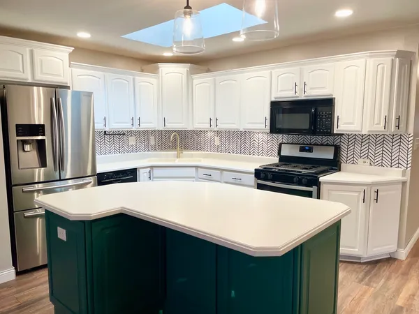 a kitchen with a sink a stove a refrigerator a center island and a window