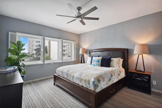 a bedroom with a large bed a chandelier and a window