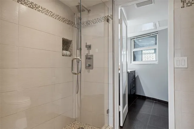 a bathroom with a shower and a glass door