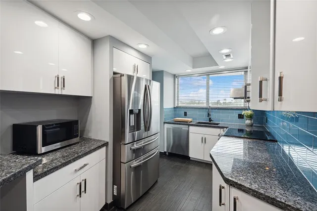 a kitchen with granite countertop stainless steel appliances and wooden cabinets
