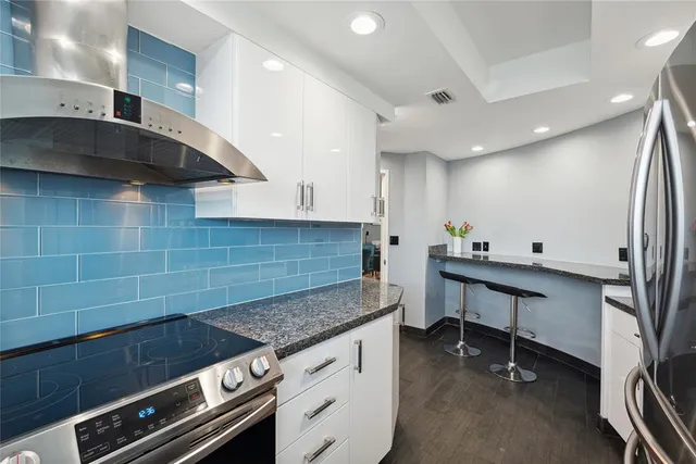 a kitchen with stainless steel appliances a sink a stove and cabinets