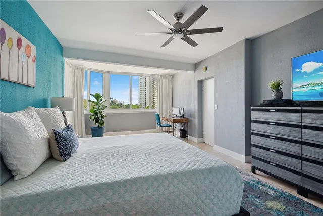 a spacious bedroom with a large bed and a chandelier