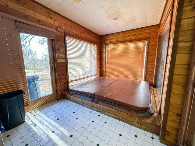 a room with pool table and windows