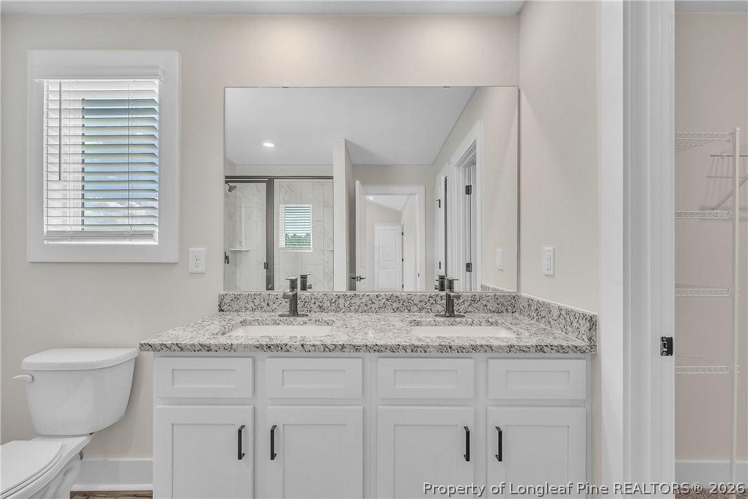 85 Camp Rock Road Lillington, NC 27546 - Photo 12 of 14 a bathroom with a granite countertop sink and a toilet