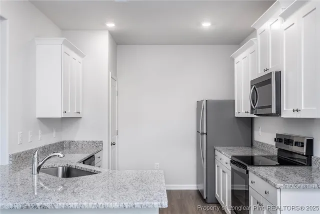 a kitchen with stainless steel appliances granite countertop a refrigerator sink and stove