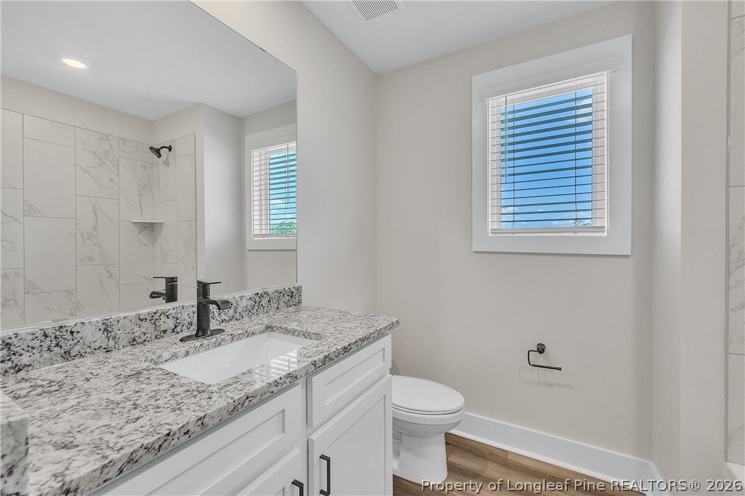 85 Camp Rock Road Lillington, NC 27546 - Photo 17 of 20 a bathroom with a granite countertop sink toilet and a mirror
