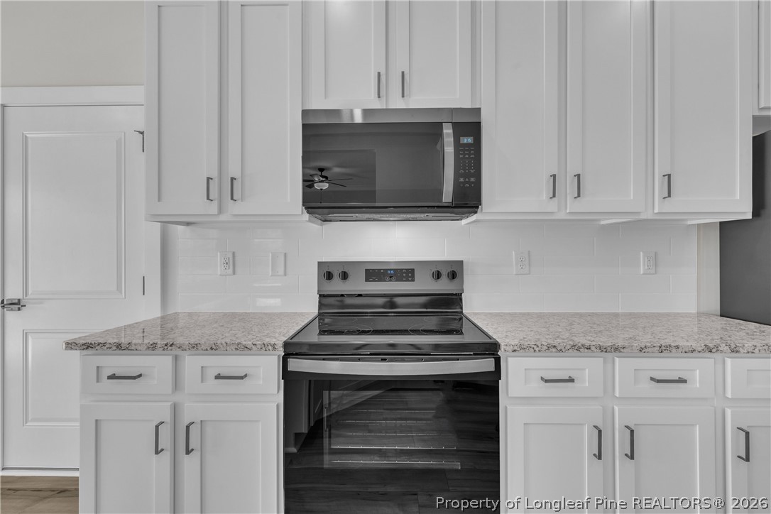 85 Camp Rock Road Lillington, NC 27546 - Photo 9 of 14 a kitchen with granite countertop white cabinets and a stove