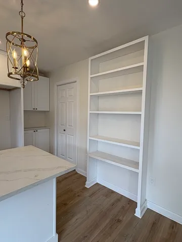 a room with a chandelier and wooden floor